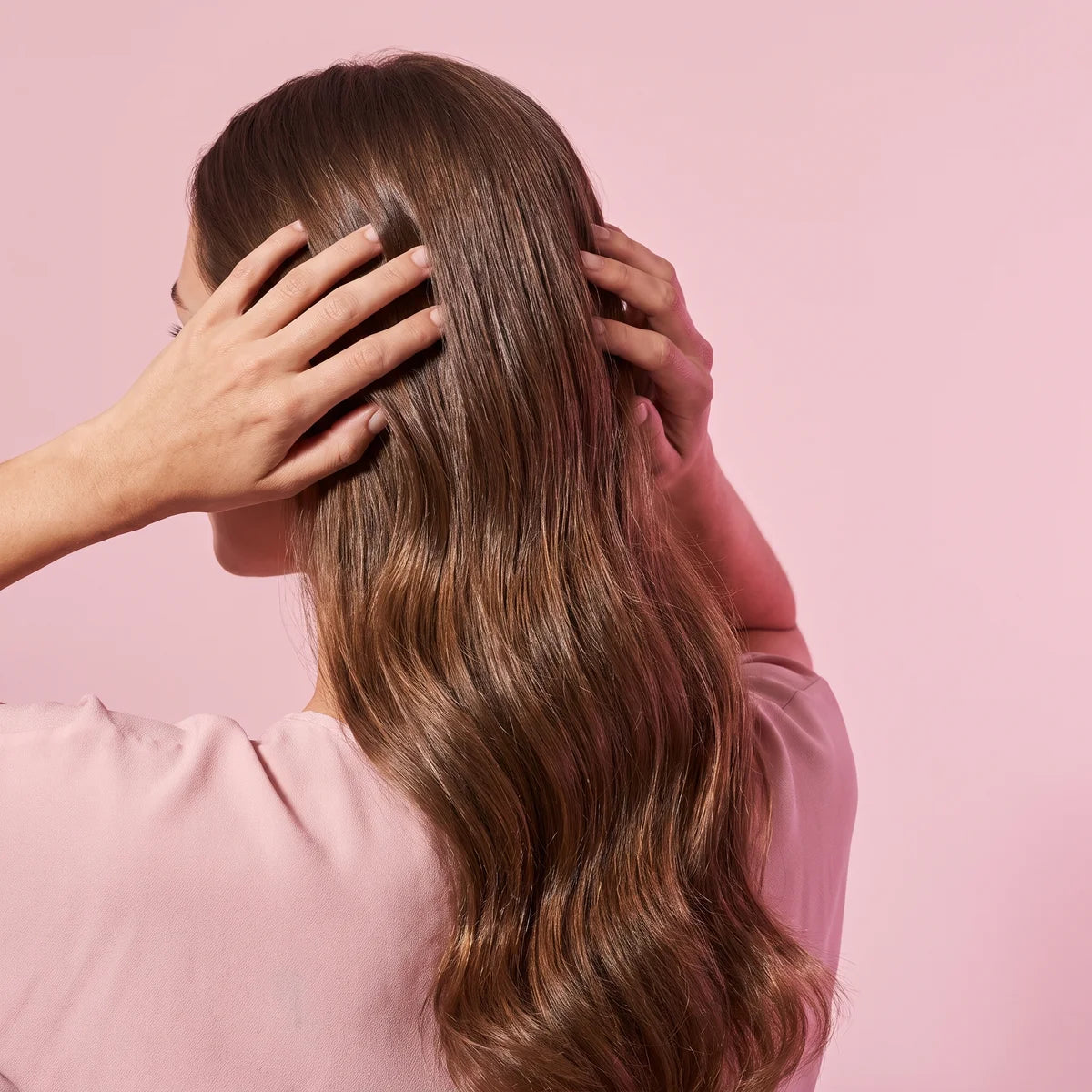 Femme massant son cuir chevelu, cheveux longs et brillants, soins cheveux Glowy