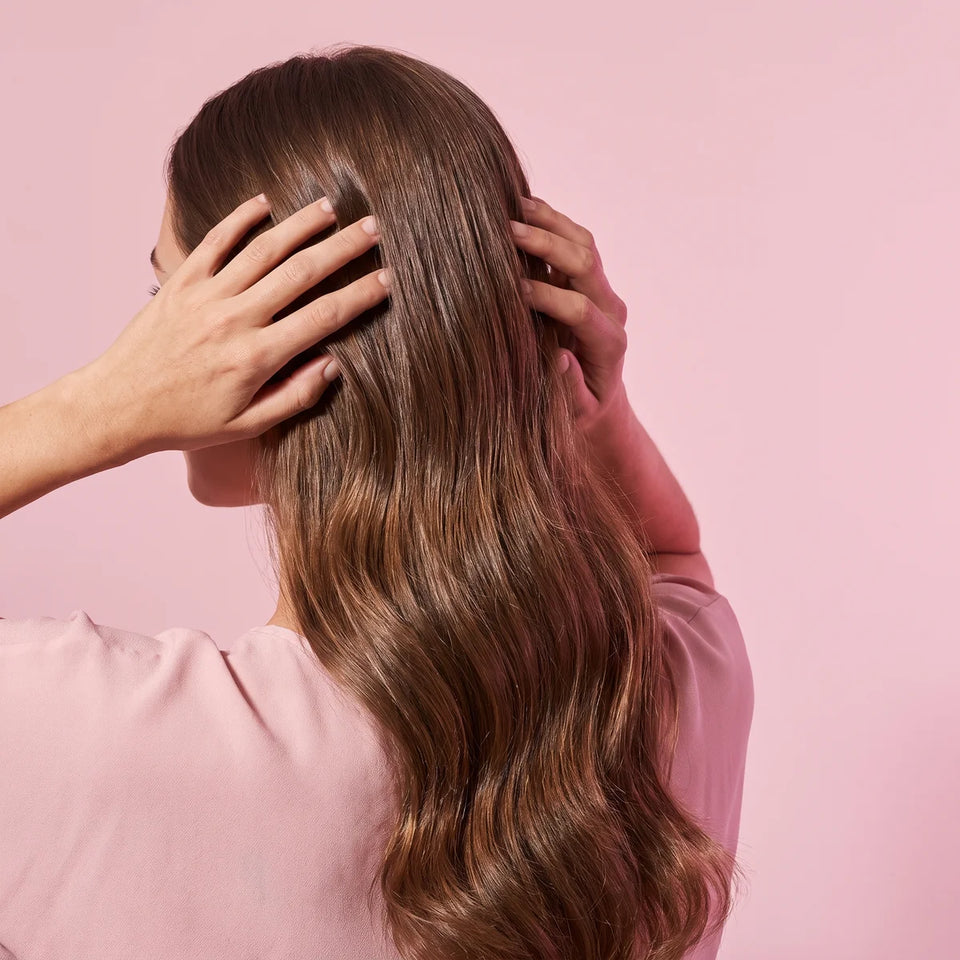Femme massant son cuir chevelu, cheveux longs et brillants, soins cheveux Glowy