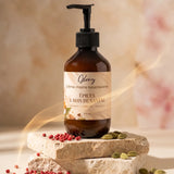Crème mains nourrissante Glowy en flacon pompe de 270 ml sur un podium en pierre, avec poivre rose et cardamome