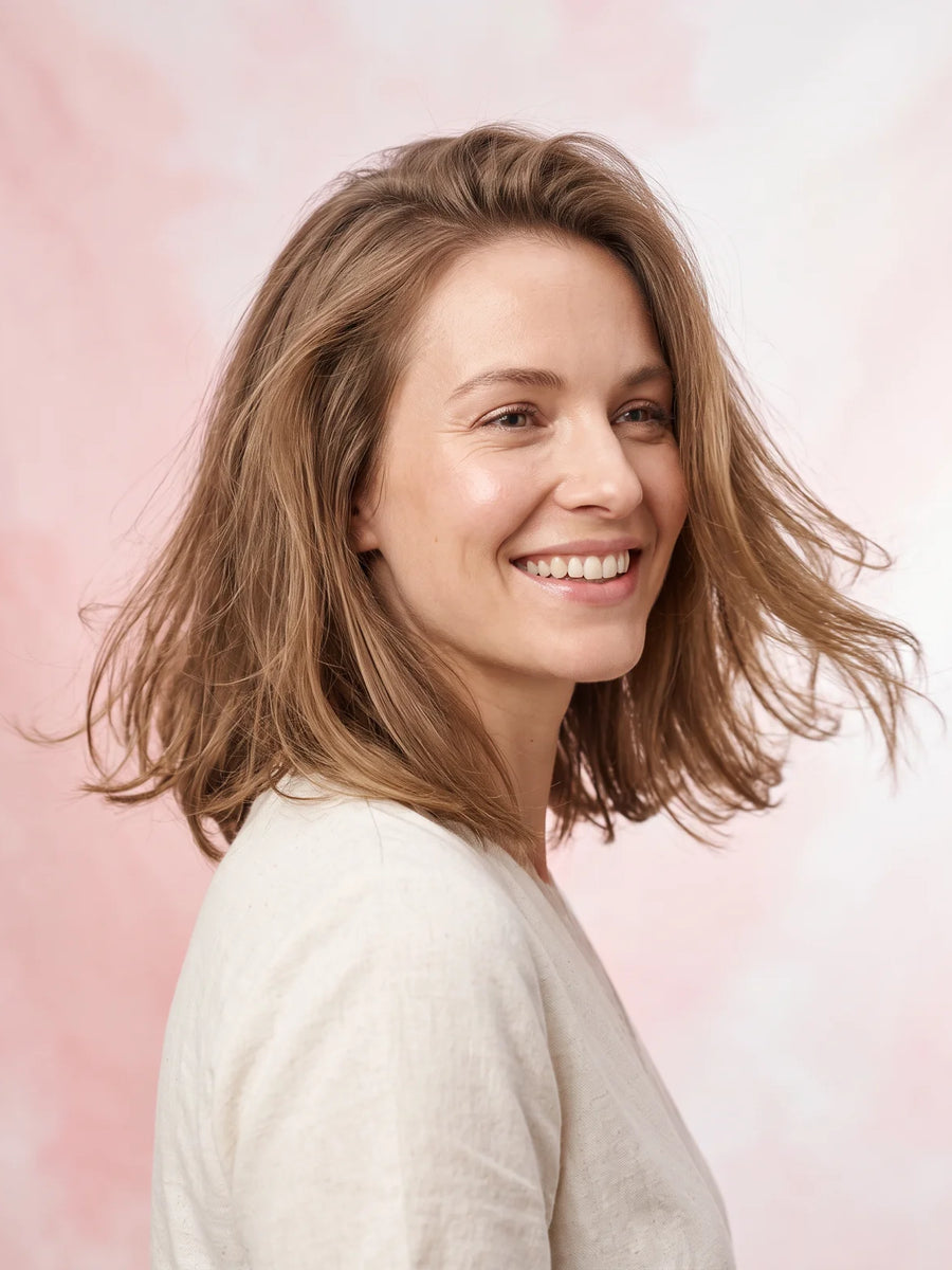 Femme souriante aux cheveux fins avec du volume aux racines